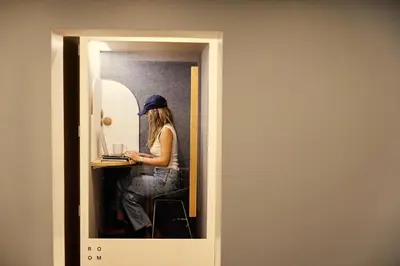 a woman sitting at a desk with a laptop at Outsite Chelsea in New York