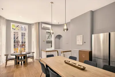 a kitchen and dining room with a table and a refrigerator at Outsite Chelsea in New York