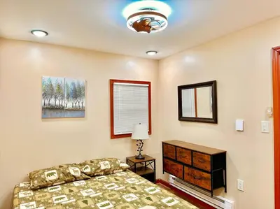 a bedroom with a bed and a dresser and a window at Chic Chalet River Views & Access in Montague