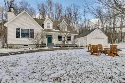a house with a table and chairs in the snow at 5 Mi to Mt Snow West Dover Getaway with Hot Tub in Brattleboro