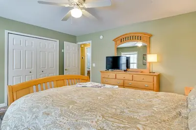 a bedroom with a bed and a dresser and a mirror at 5 Mi to Mt Snow West Dover Getaway with Hot Tub in Brattleboro