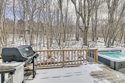 a snow covered deck with a hot tub and a grill at 5 Mi to Mt Snow West Dover Getaway with Hot Tub in Brattleboro