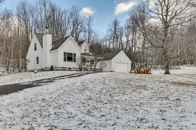 a white house with snow on the ground at 5 Mi to Mt Snow West Dover Getaway with Hot Tub in Brattleboro