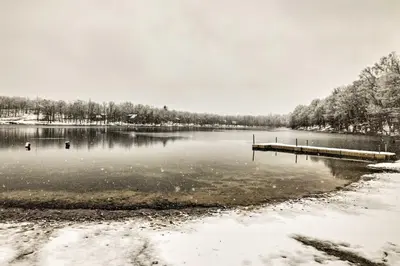 a lake with a dock in the snow at Hot Tub and Deck Pet-Friendly Poconos Getaway! in Bushkill