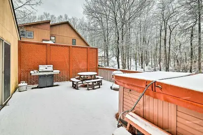 a backyard covered in snow with a grill and picnic tables at Hot Tub and Deck Pet-Friendly Poconos Getaway! in Bushkill