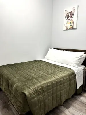 a bedroom with a bed with a green blanket on it at Newly 5 Star 3 Beds 1 Bath ideal Short term rental in Schenectady
