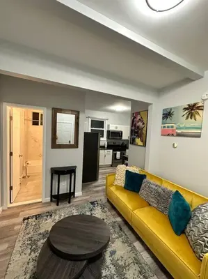 a living room with a yellow couch and a table at Newly 5 Star 3 Beds 1 Bath ideal Short term rental in Schenectady