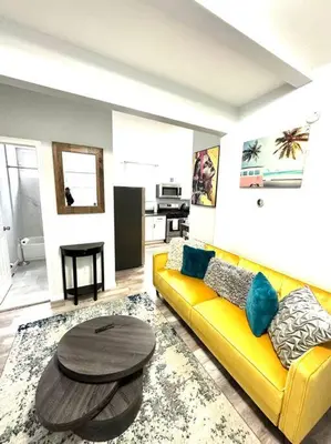 a living room with a yellow couch and a table at Newly 5 Star 3 Beds 1 Bath ideal Short term rental in Schenectady