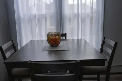 a dining room table with a vase on top of it at Modern, Luxury 2 Bedroom Apt in Prime Location in Schenectady