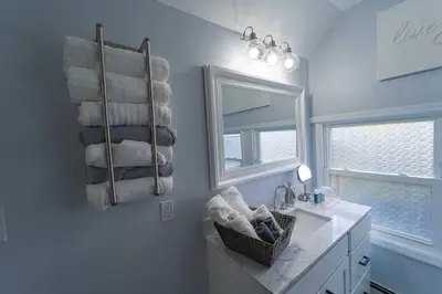 a bathroom with a sink and a mirror and towels at Modern, Luxury 2 Bedroom Apt in Prime Location in Schenectady