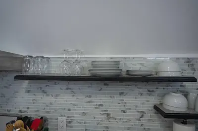 a shelf with plates and glasses and dishes on it at Modern, Luxury 2 Bedroom Apt in Prime Location in Schenectady