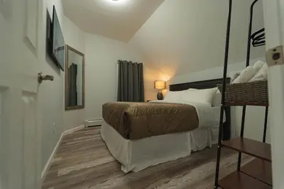 a bedroom with a large bed with a wooden floor at Modern, Luxury 2 Bedroom Apt in Prime Location in Schenectady
