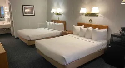 a hotel room with two beds with white pillows at Commack Inn in Commack