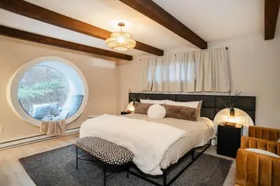 a bedroom with a large bed and a large window at Catskill MNTN Escape 5 BR 3 bath Villa Hot Tub Fire Pit Best Group Stay in Prattsville