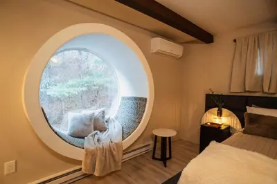 a bedroom with a large round window and a bed at Catskill MNTN Escape 5 BR 3 bath Villa Hot Tub Fire Pit Best Group Stay in Prattsville