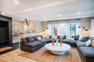 a living room with blue couches and a table at Catskill MNTN Escape 5 BR 3 bath Villa Hot Tub Fire Pit Best Group Stay in Prattsville