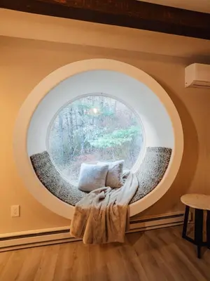 a circular window in a room with a couch at Catskill MNTN Escape 5 BR 3 bath Villa Hot Tub Fire Pit Best Group Stay in Prattsville