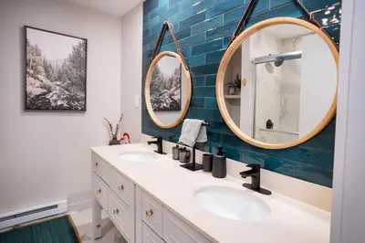 a bathroom with two sinks and two mirrors at Catskill MNTN Escape 5 BR 3 bath Villa Hot Tub Fire Pit Best Group Stay in Prattsville