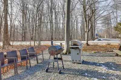 a grill and chairs in a park with trees at 8 Mi to Tobyhanna State Park Poconos Home! in Mushroom Farms