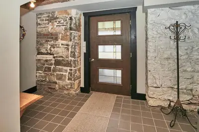 a hallway with a door and a stone wall at Craftsman Hideaway at the 1841 Farmhouse in Chester