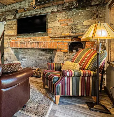 a living room with a couch and a lamp at 1786 Farm Cottage Honeymoon Suite Renovated 2022 in Chester