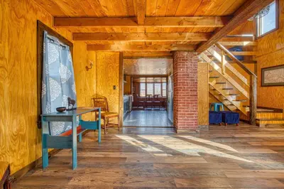 a room with a table and a brick wall at Catskills Cottage with Deck, 7 Mi to Hunter Mtn in Elka Park