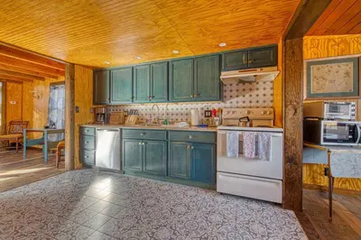 a kitchen with green cabinets and a white refrigerator at Catskills Cottage with Deck, 7 Mi to Hunter Mtn in Elka Park