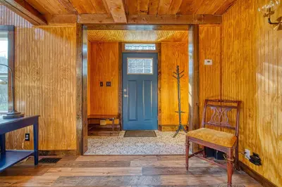 a wooden hallway with a blue door and a chair at Catskills Cottage with Deck, 7 Mi to Hunter Mtn in Elka Park