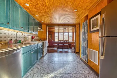 a kitchen with green cabinets and a dining room at Catskills Cottage with Deck, 7 Mi to Hunter Mtn in Elka Park