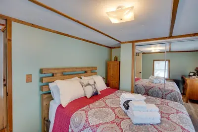a bedroom with two beds and a mirror at Cozy Catskills Home with Pond on 2 Acres! in Earlton