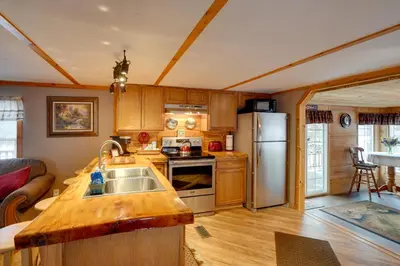 a kitchen with a sink and a refrigerator at Cozy Catskills Home with Pond on 2 Acres! in Earlton