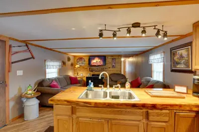 a kitchen with a sink and a living room at Cozy Catskills Home with Pond on 2 Acres! in Earlton
