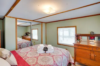 a bedroom with a bed with a dresser and a mirror at Cozy Catskills Home with Pond on 2 Acres! in Earlton