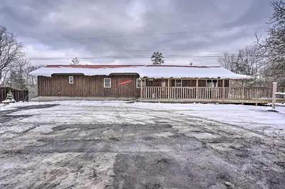 a house with a snow covered roof on a dirt road at Cozy Catskills Home with Pond on 2 Acres! in Earlton