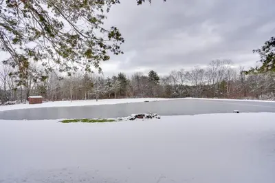 a frozen pond with snow on the ground at Cozy Catskills Home with Pond on 2 Acres! in Earlton