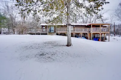 a log home in the snow with a tree at Cozy Catskills Home with Pond on 2 Acres! in Earlton