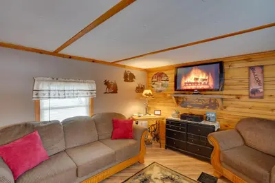 a living room with a couch and a flat screen tv at Cozy Catskills Home with Pond on 2 Acres! in Earlton