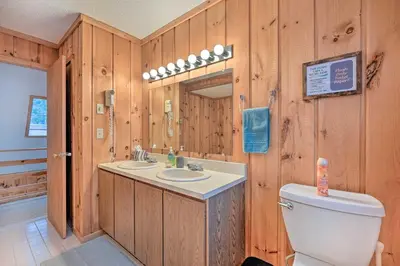 a bathroom with wooden walls and a toilet and a sink at Relaxing Home Mins from Mt Snow, Hiking, and Lakes in Dover