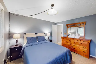 a bedroom with a blue bed and a dresser and a mirror at Glorious Scenery in Dover