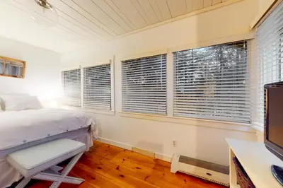 a bedroom with a bed and a desk and two windows at Little Red in Wilmington