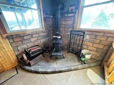 a room with a brick wall with a stove at Close to skiing and hiking, walk to main street in Tannersville