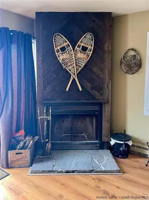 a fireplace with two butterfly decorations on the wall at Close to skiing and hiking, walk to main street in Tannersville