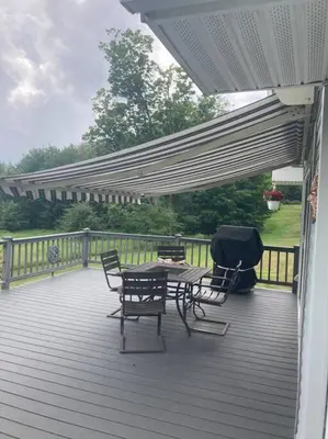 a patio with a table and chairs on a deck at Close to skiing and hiking, walk to main street in Tannersville
