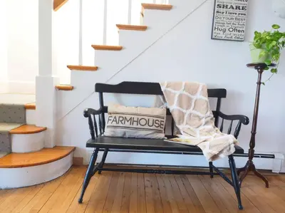 a bench with a blanket on it in a room with stairs at Casa al Mare Beachfront Retreat King Bed Near Yale in East Haven