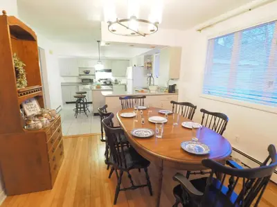 a kitchen and dining room with a wooden table and chairs at Casa al Mare Beachfront Retreat King Bed Near Yale in East Haven