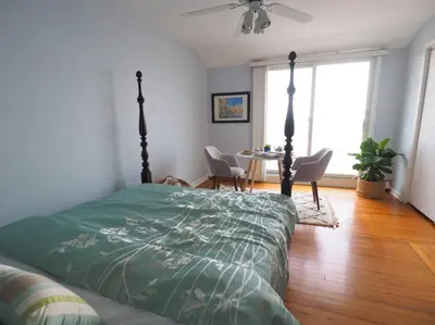 a bedroom with a bed and a table with chairs at Casa al Mare Beachfront Retreat King Bed Near Yale in East Haven