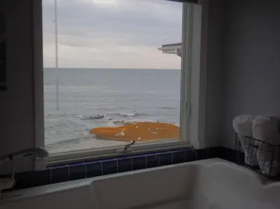 a bathroom with a view of the ocean from a window at Casa al Mare Beachfront Retreat King Bed Near Yale in East Haven