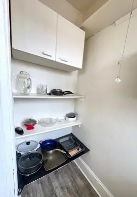 a kitchen with white shelves and pots and pans at The Elizabeth Suite B2 in Hartford