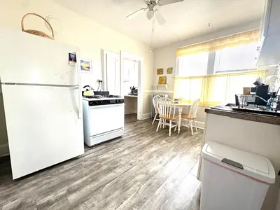 a kitchen with a white refrigerator and a table at The Elizabeth Suite B2 in Hartford