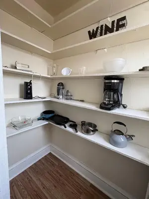 a kitchen with white shelves with pots and pans at The Bushnell Suite C2 in Hartford
